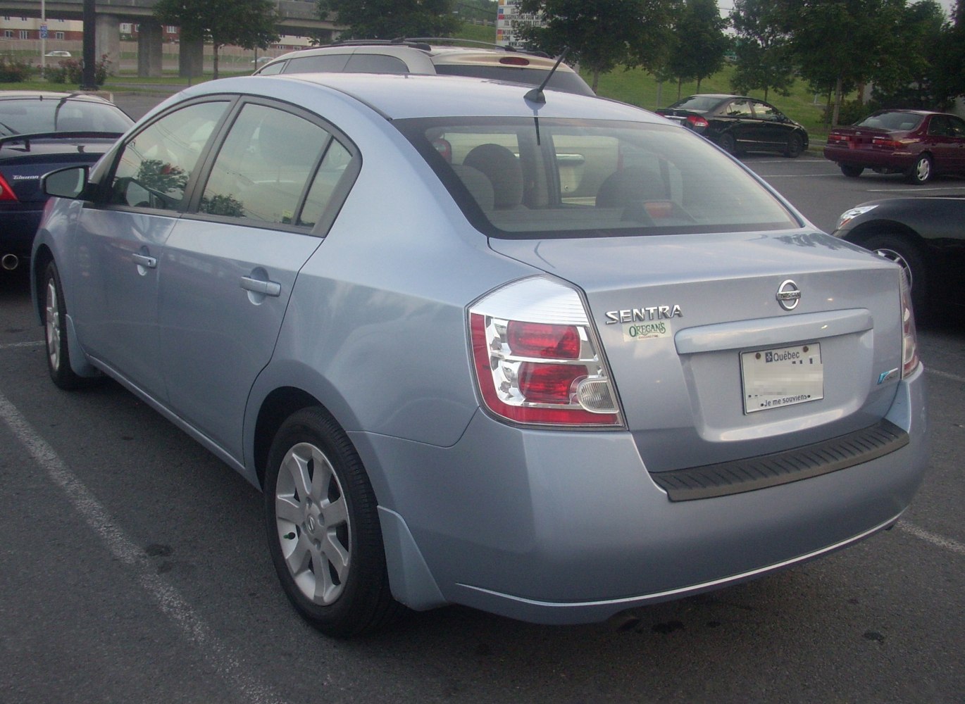 Compact four-door sedan rear with distinctive taillights and hatchback trunk.