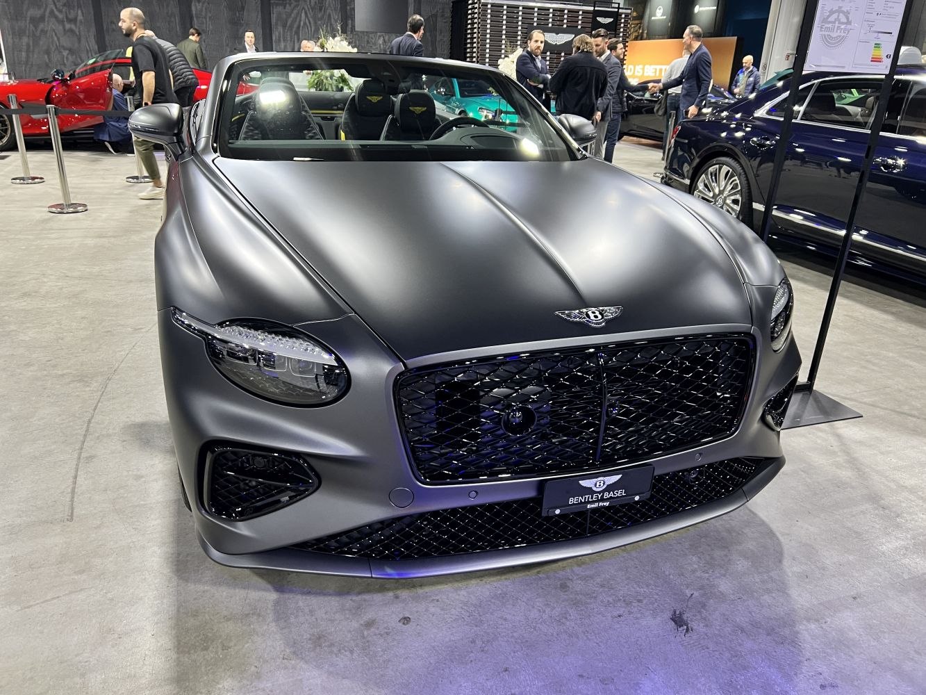 Front view of a matte black convertible with distinctive grille and headlights