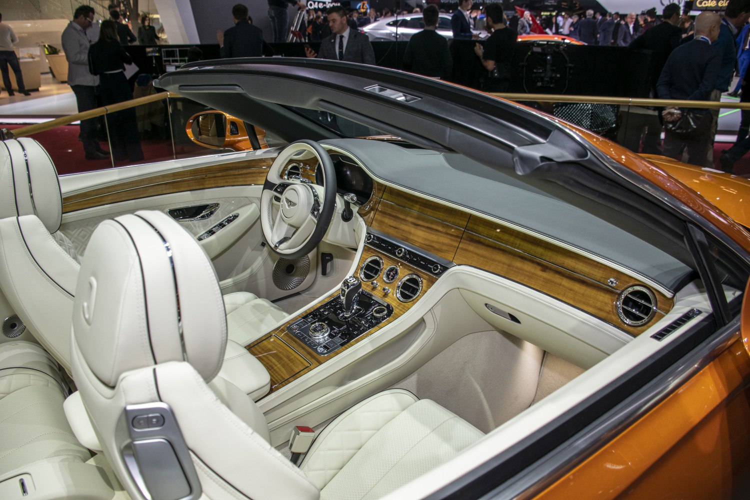 Luxury convertible interior with white leather seats and detailed wood trim dashboard