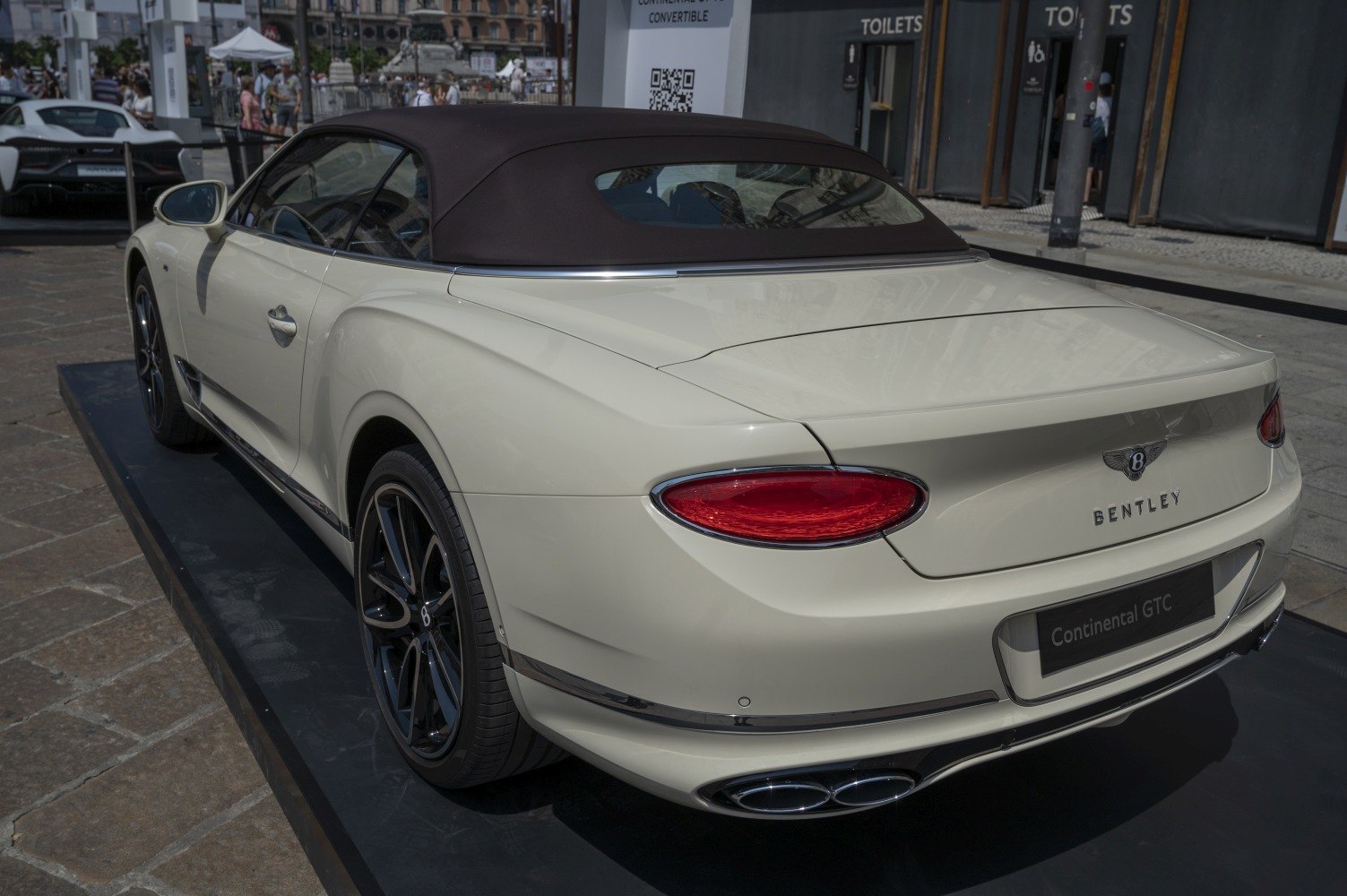 Convertible with soft top roof and rear view showing taillights and dual exhaust