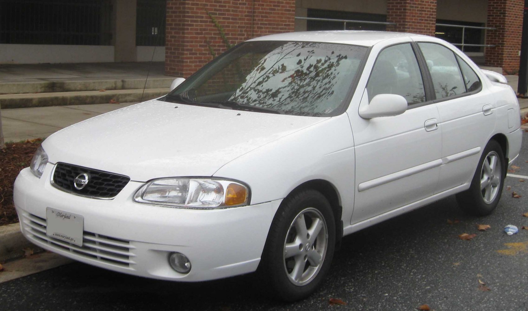 White sedan showing front side view with headlights and grille