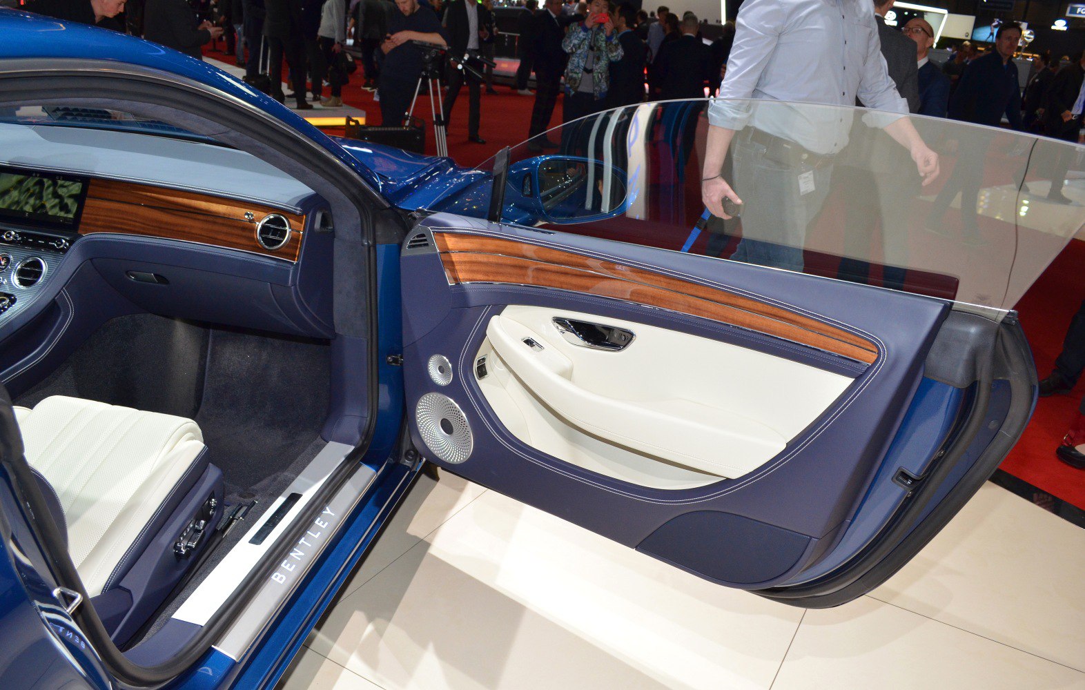 Luxury car door interior with wood trim and leather upholstery.