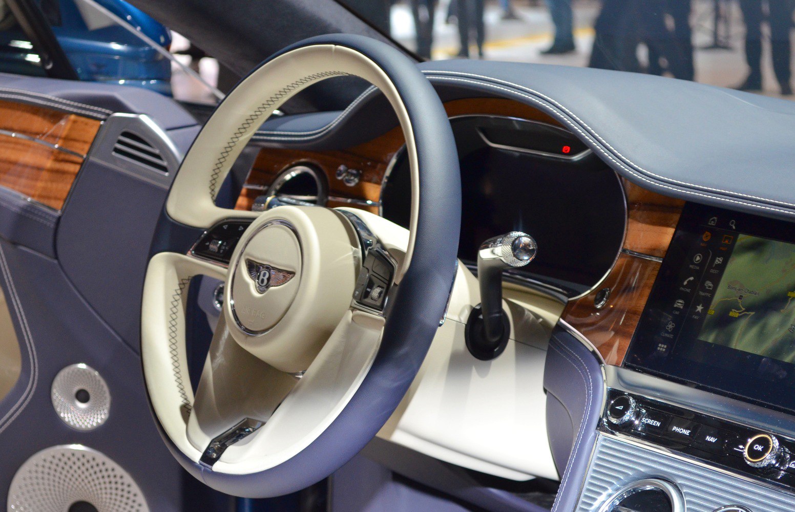 Luxury car interior with leather steering wheel and wood trim