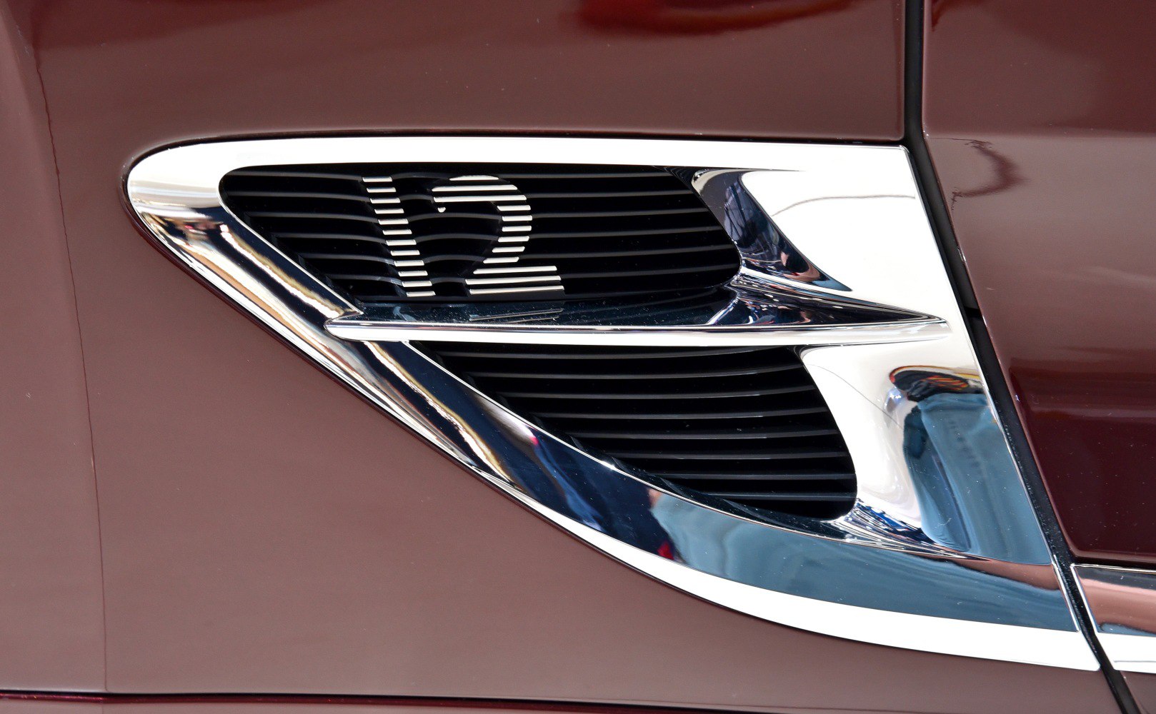 V12 emblem and chrome side vent on car body