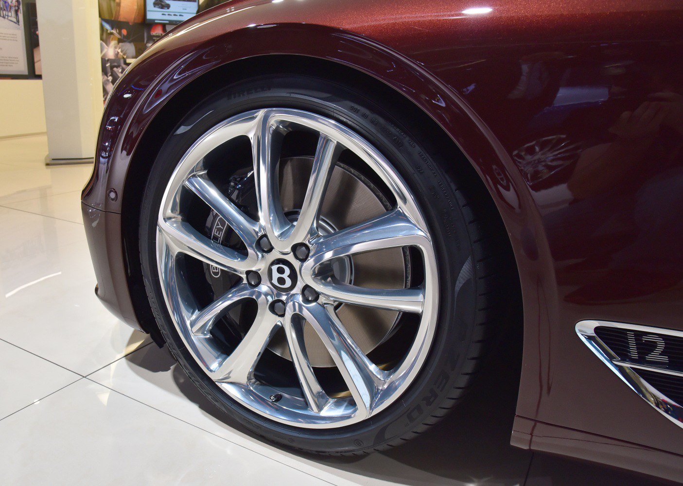 Polished alloy wheel with Bentley badge and brake caliper.