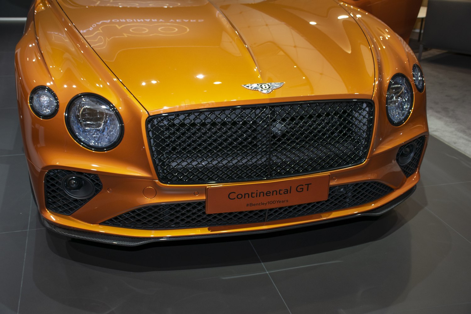 Luxury front grille and round headlights of a Bentley luxury sports coupe.