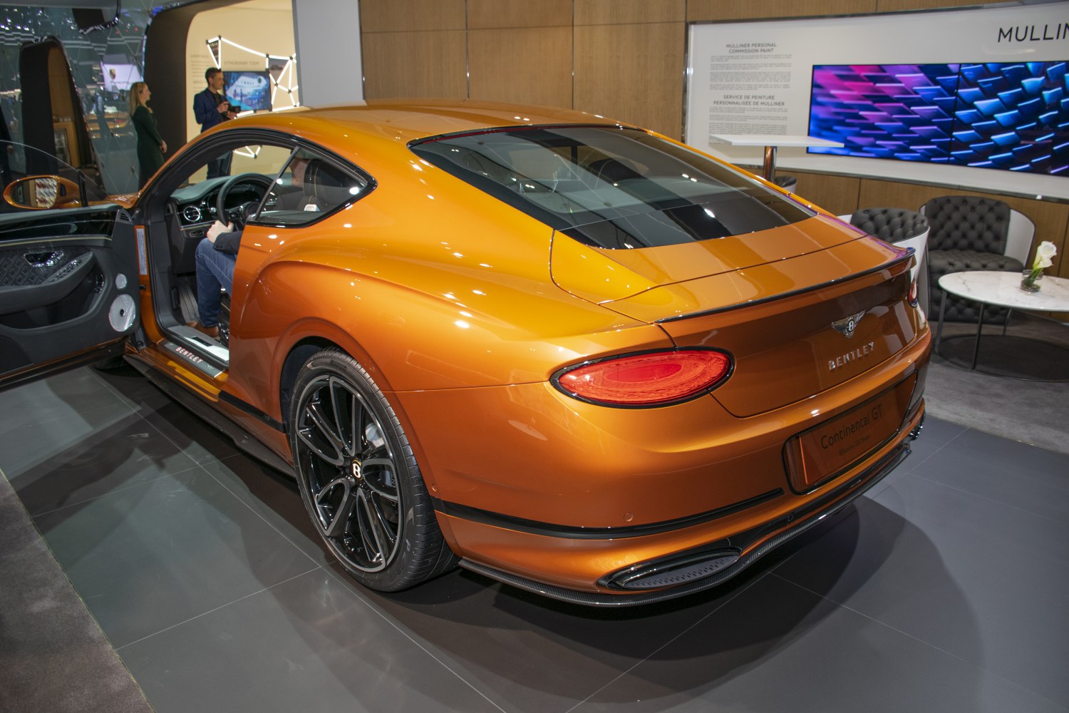 Rear view and interior of orange luxury coupe with black wheels