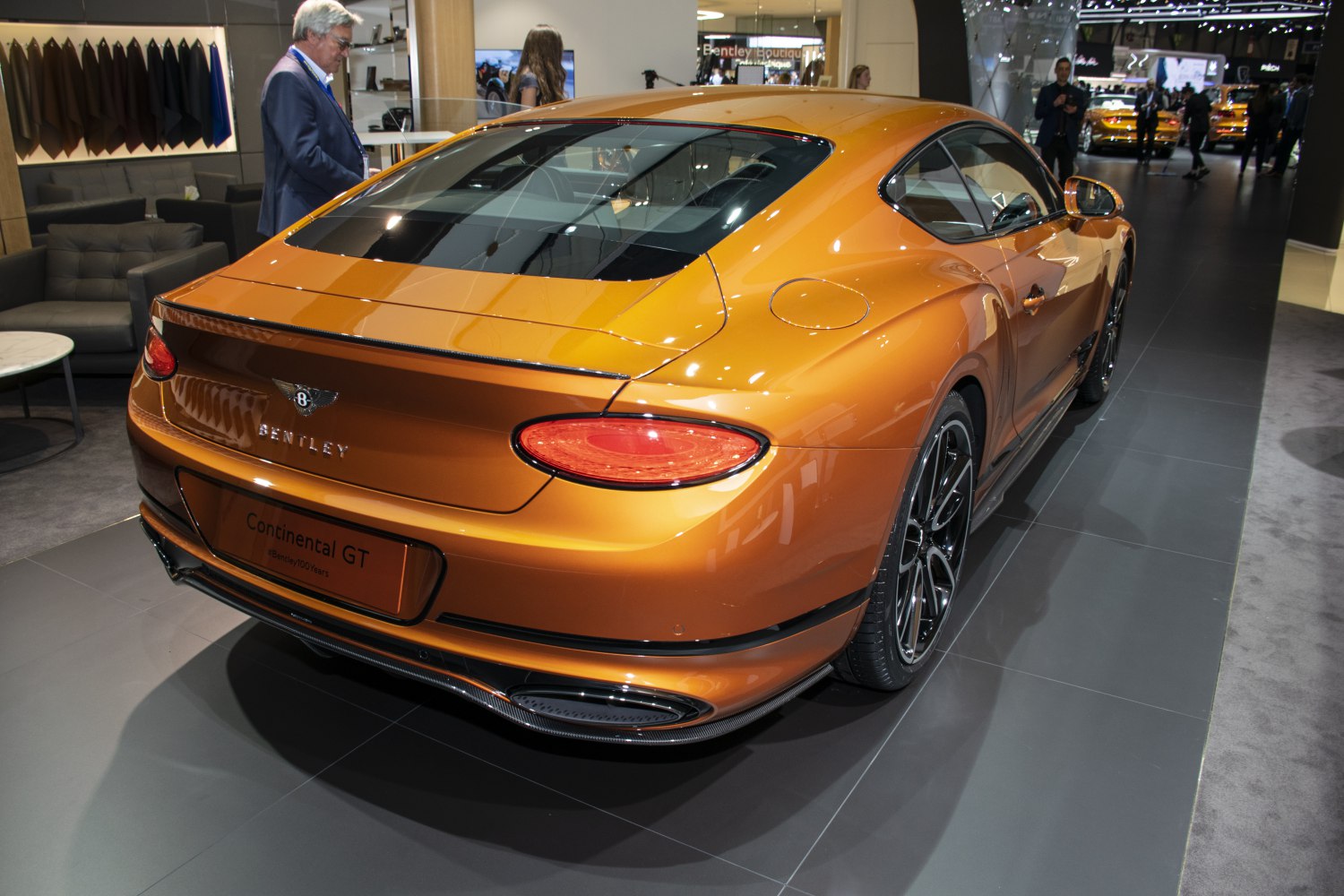 Rear view of an orange luxury coupe with distinctive taillights and aerodynamic styling