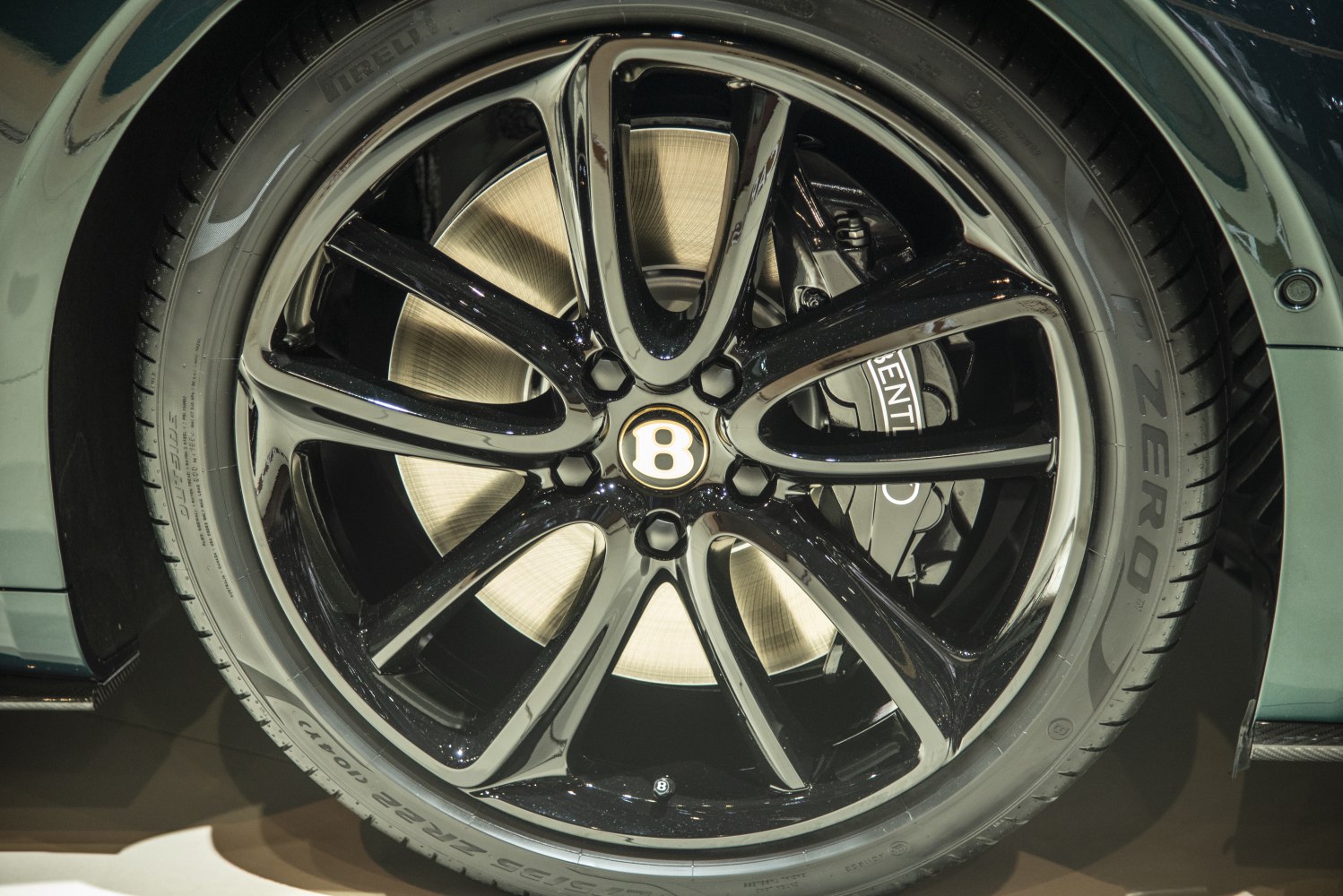 Close-up of black alloy wheel with brake caliper and Pirelli tire
