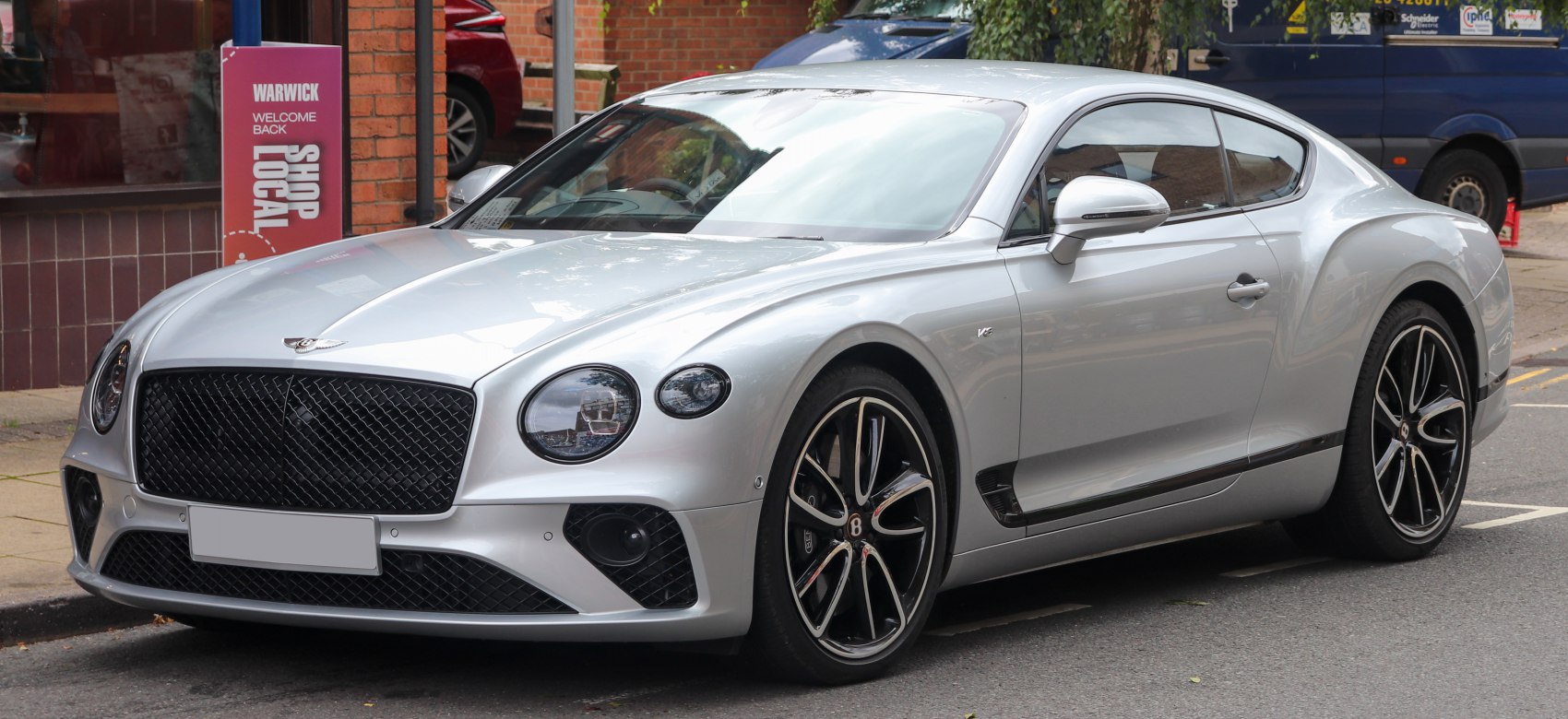 Silver luxury sports coupe with V8 badge and distinctive alloy wheels