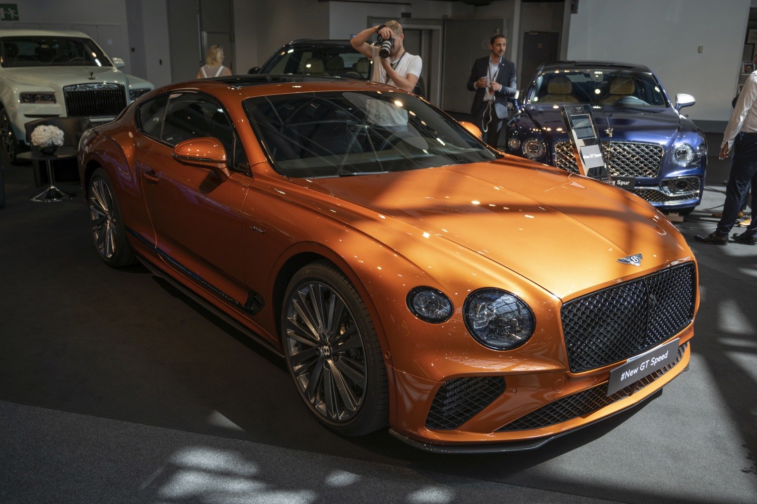 Luxury orange sports coupe with distinctive front grille and round headlights