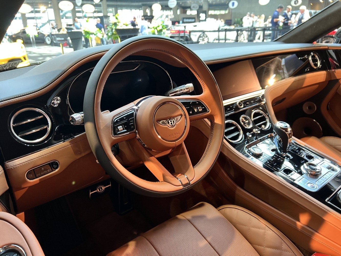 Tan leather steering wheel and dashboard with chrome accents.