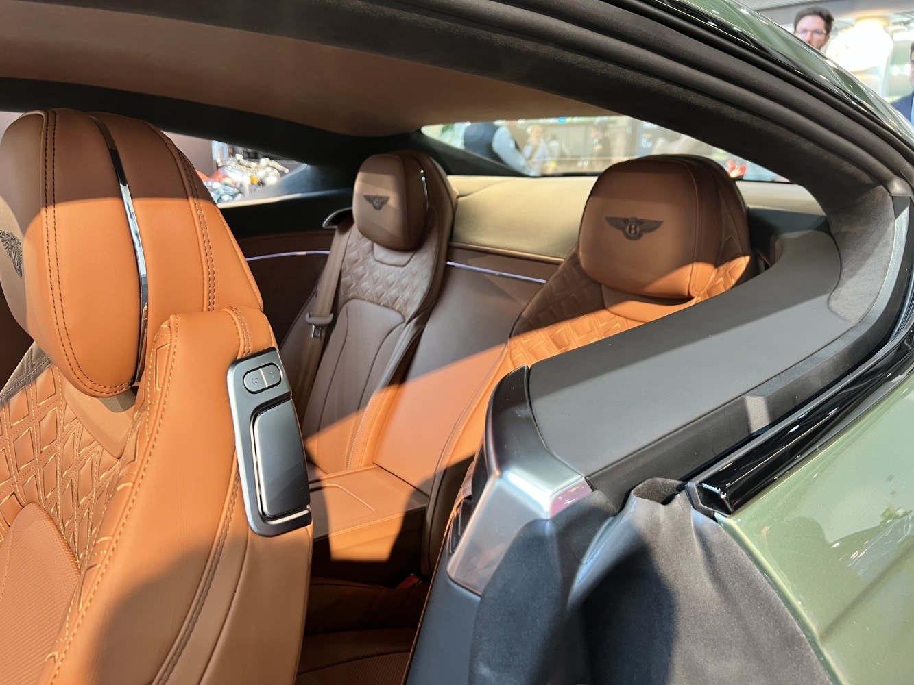 Tan leather seats with embroidered logos and quilted patterns