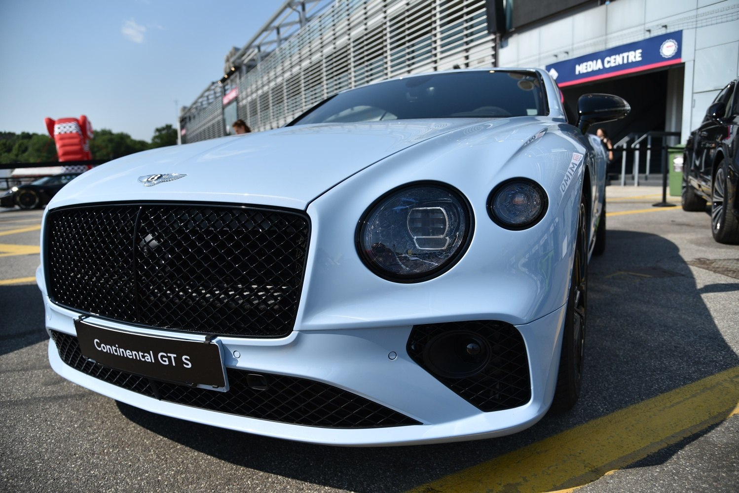Close-up of car front with dual round headlights and black mesh grille