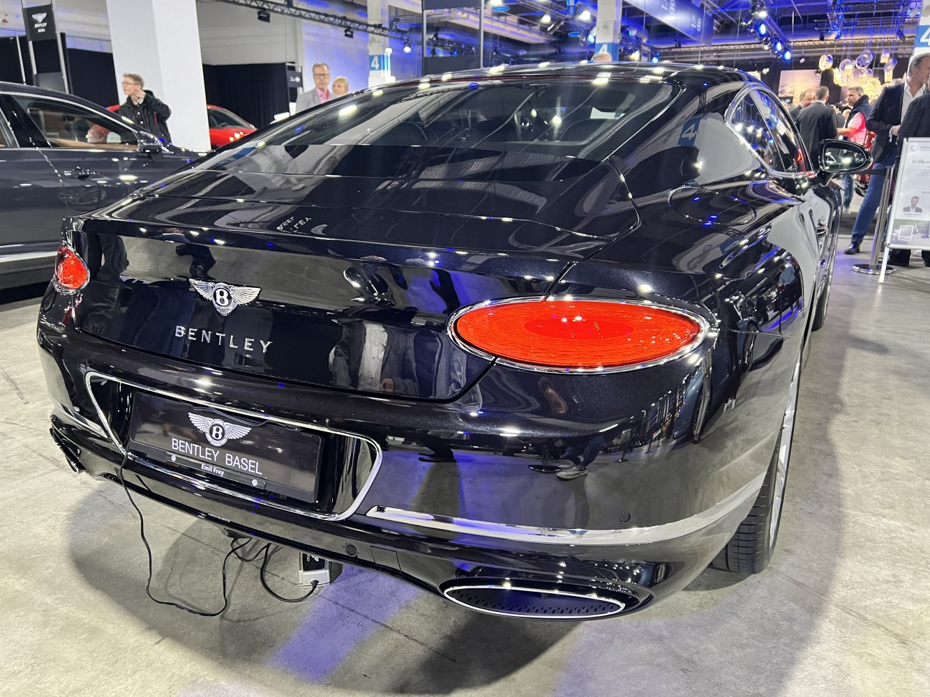 Luxury coupe rear with oval red tail lights and dual exhaust tips