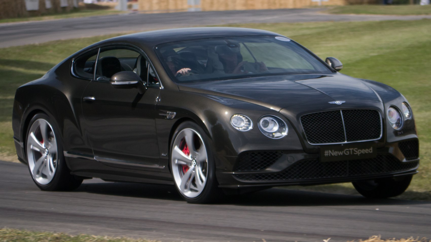 Front and side view of luxury coupe with round headlights and alloy wheels
