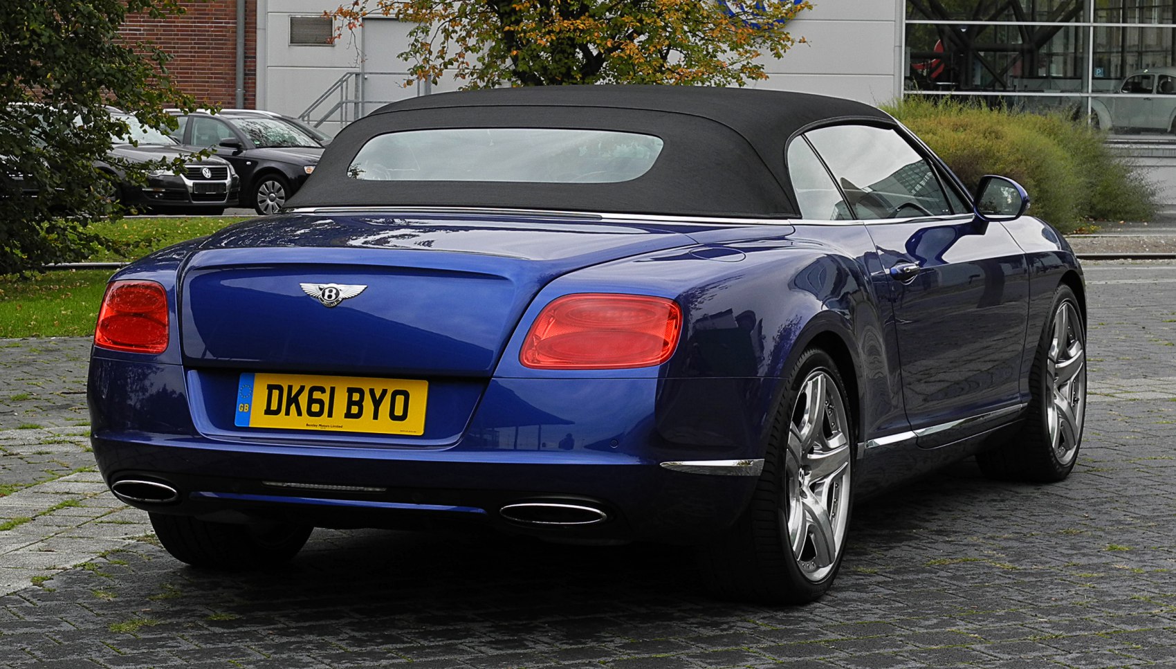 Rear view of blue soft top convertible with dual exhausts