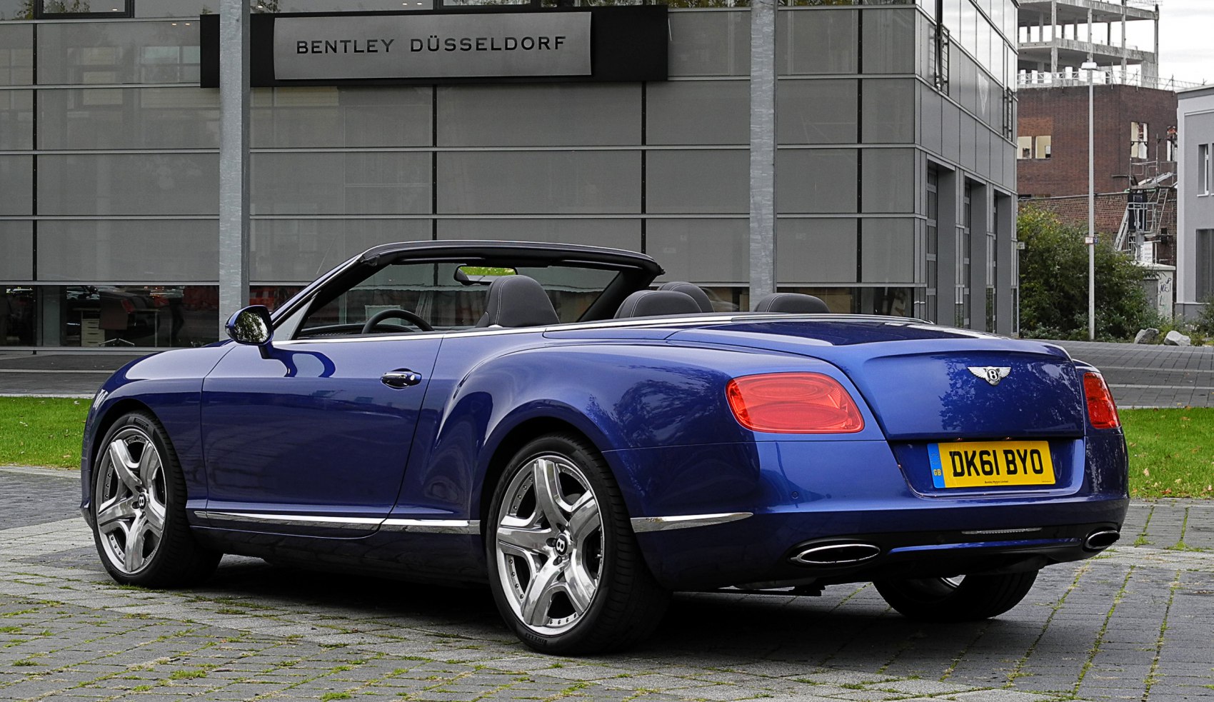 Convertible luxury car rear with alloy wheels and blue paint