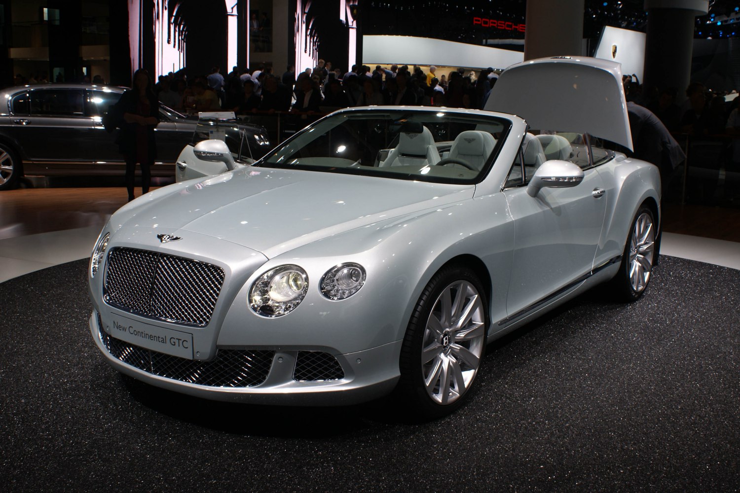 Silver convertible luxury vehicle with iconic Bentley grille and detailed headlamps