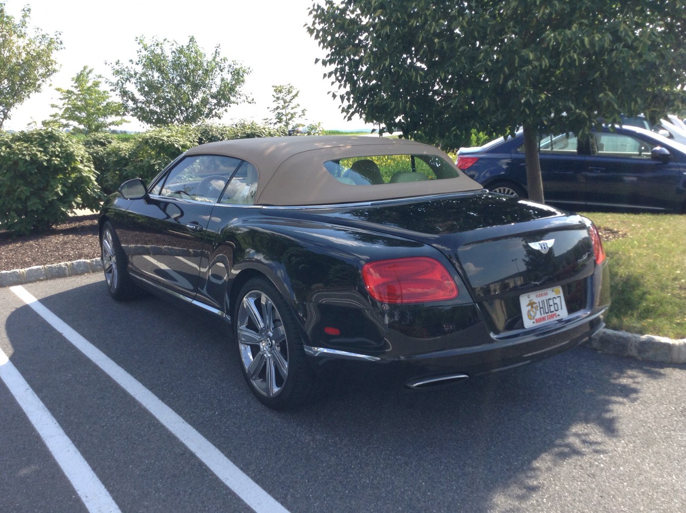 Rear and side view of convertible with beige soft top and black body