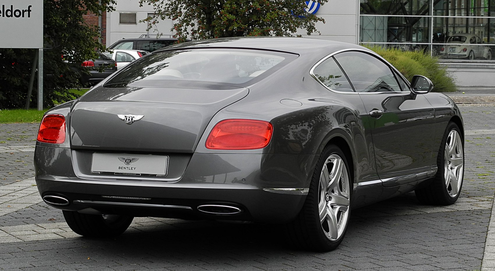 Sleek luxury coupe rear with distinctive taillights and chrome exhausts
