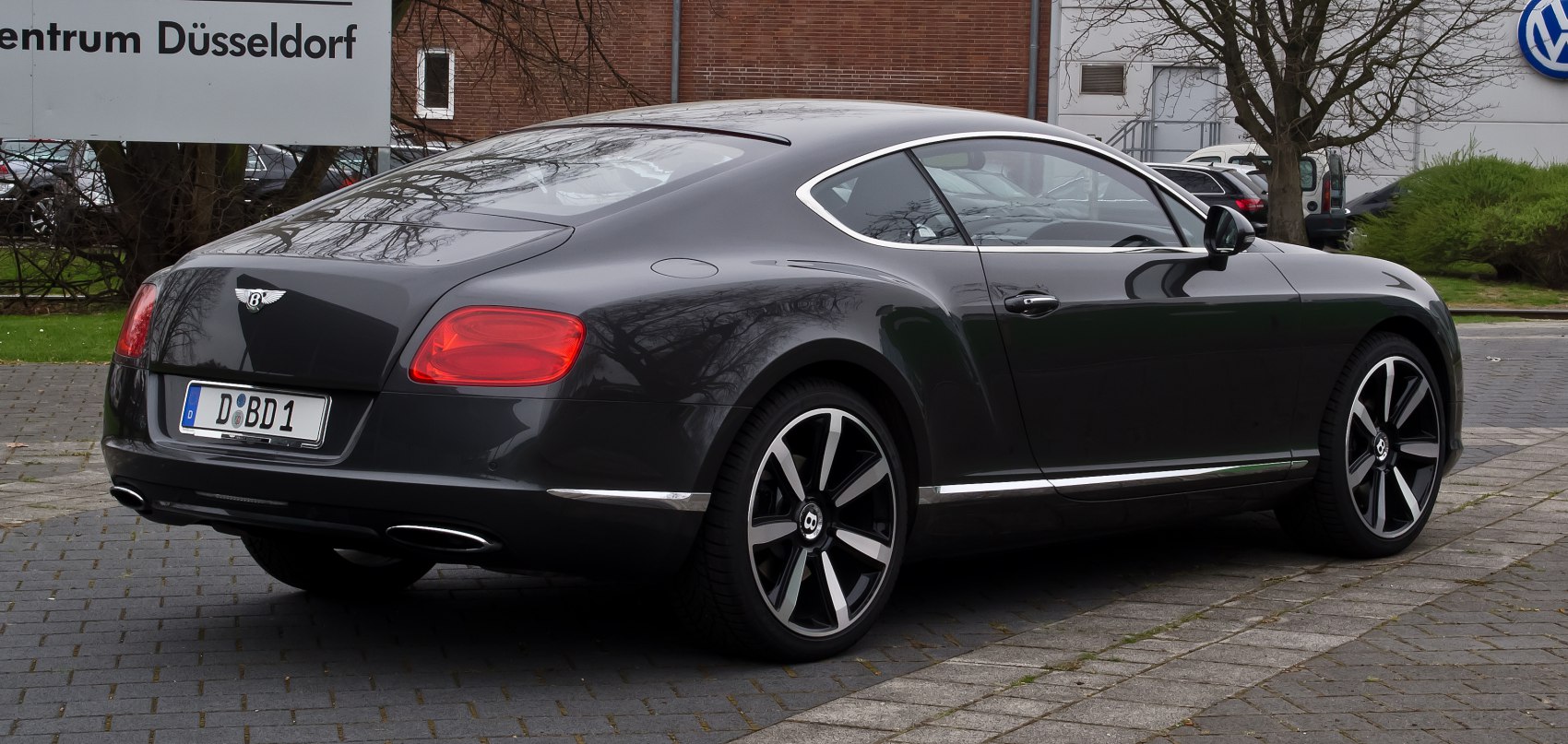 Rear and side profile of a luxury coupe with alloy wheels and dual exhausts