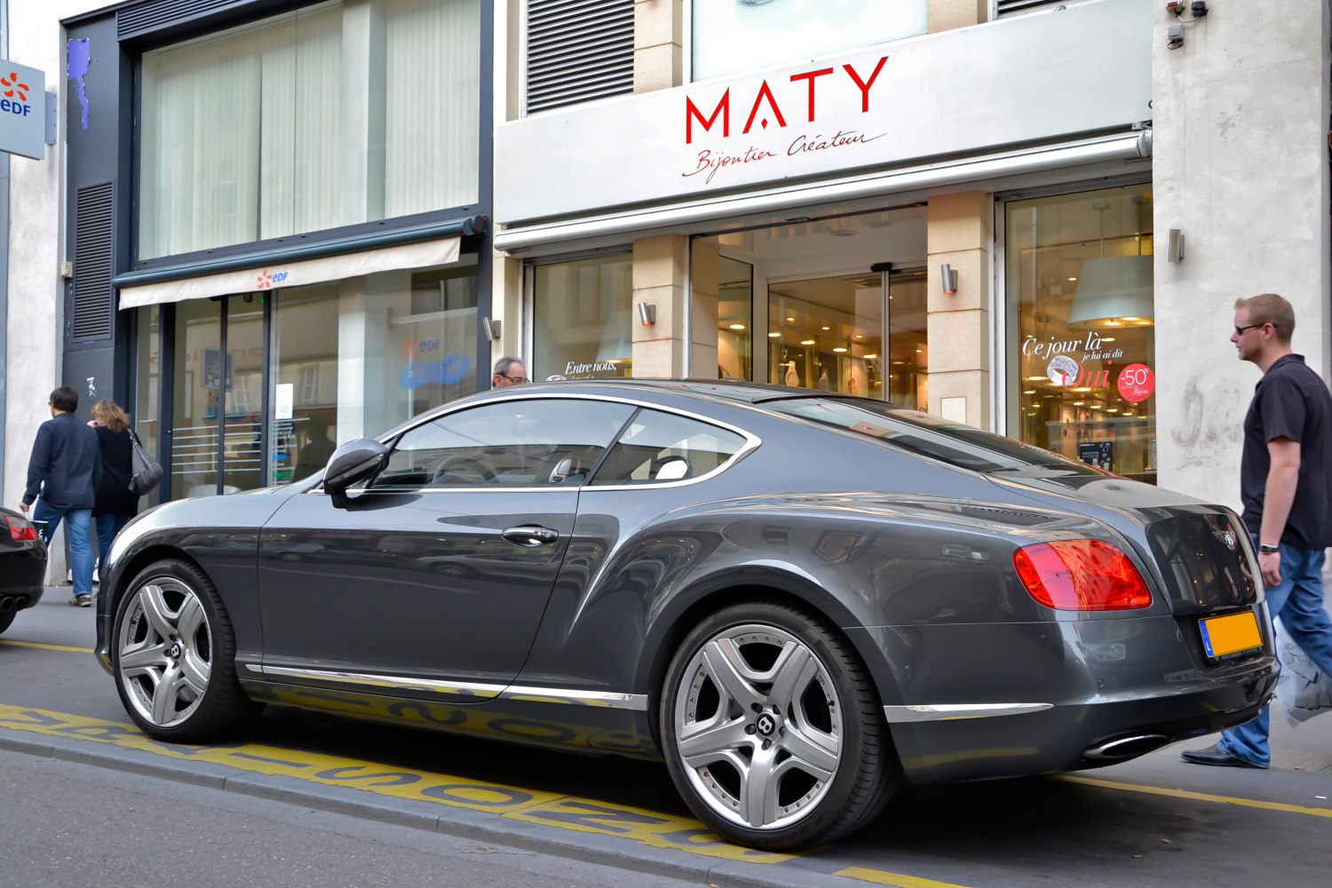 Side profile of a luxury coupe with alloy wheels and rear taillights