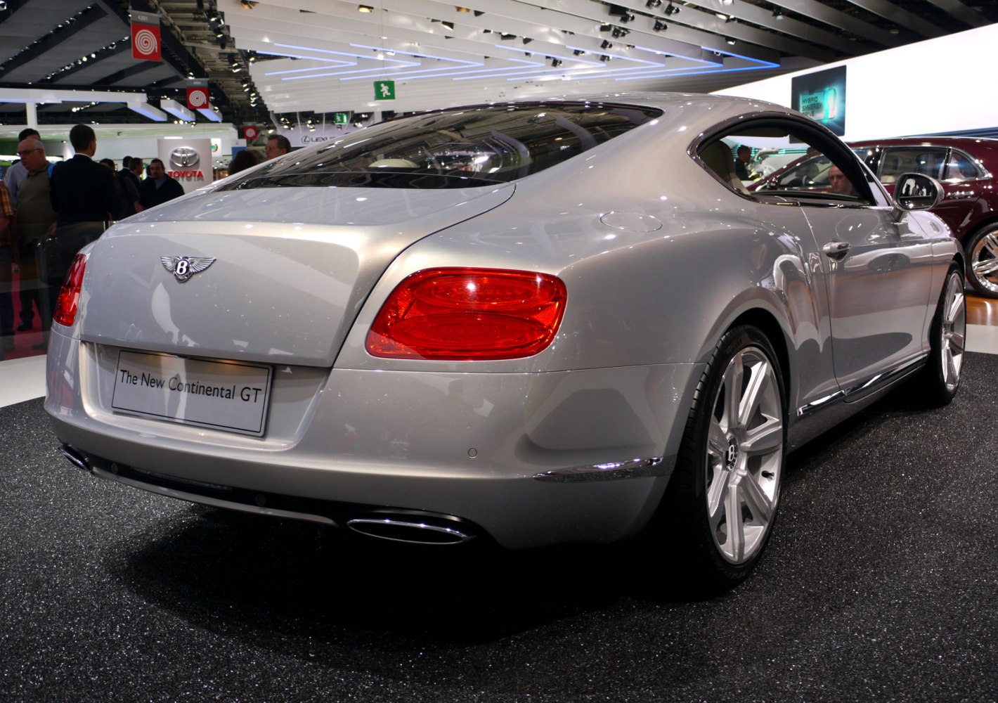 Rear view of luxury coupe with red taillights and dual exhaust.