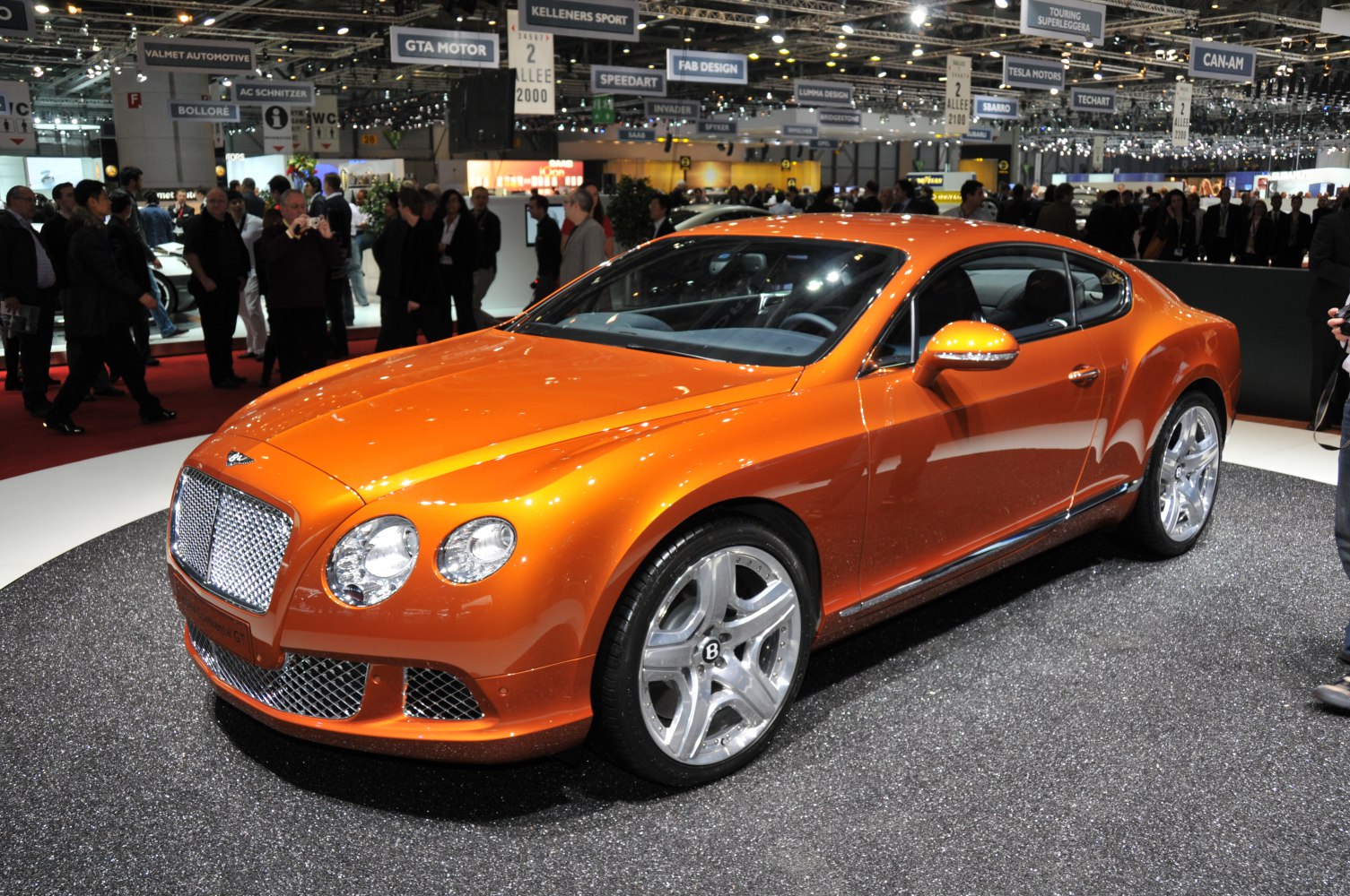 Orange luxury coupe with rounded headlights and polished alloy wheels