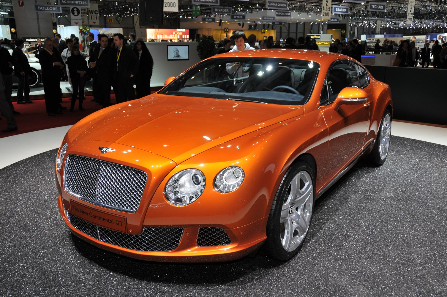 Shiny orange sports coupe with prominent front grille and round headlights