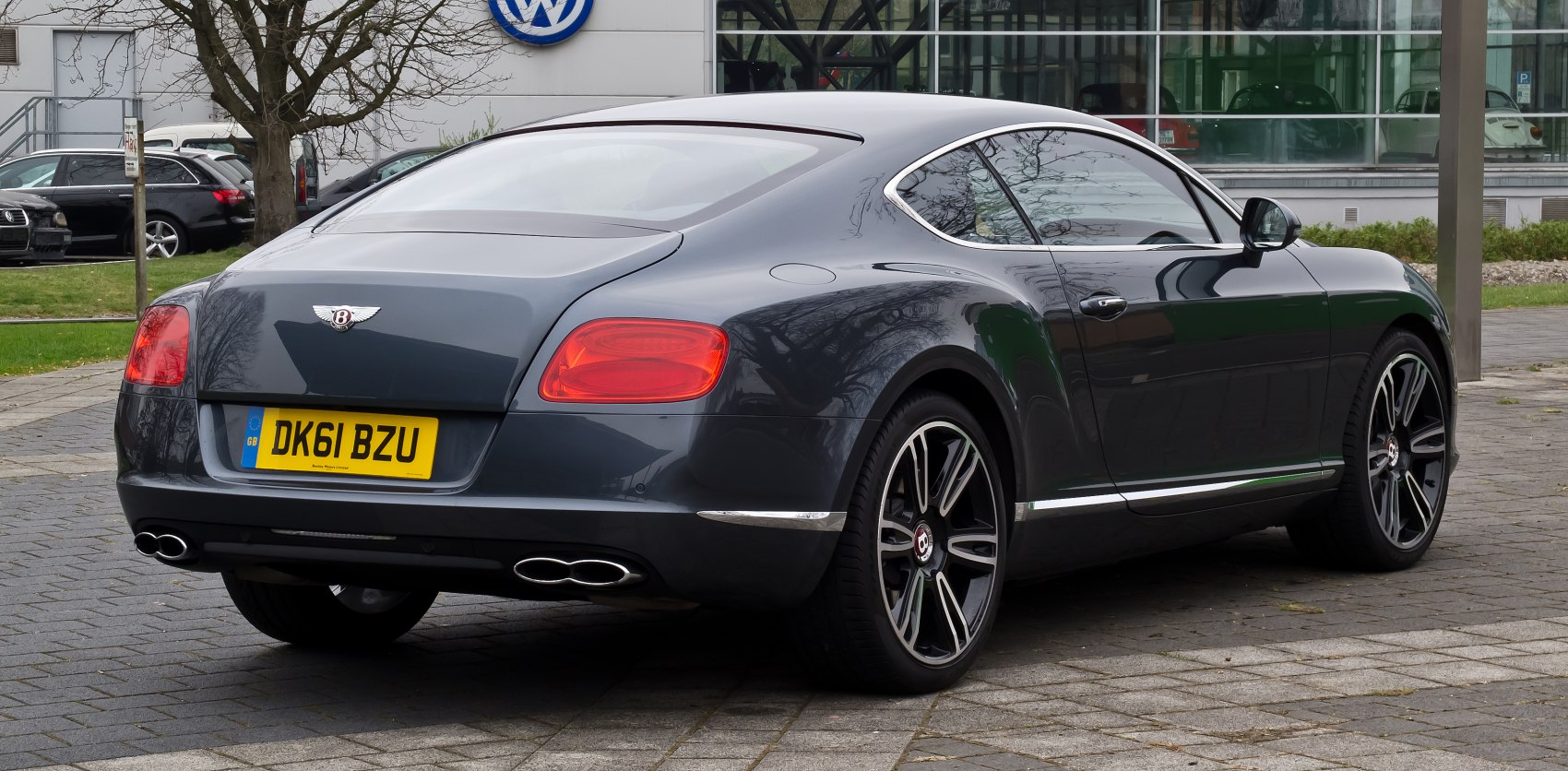 Luxury coupe rear with tail lights, dual exhaust, alloy wheels