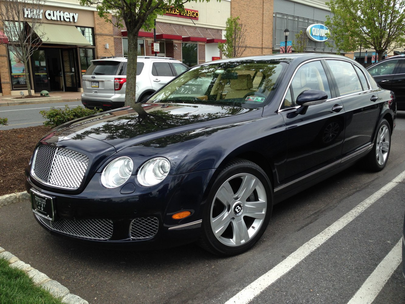 Luxury sedan with mesh grille, dual round headlights, and silver alloy wheels
