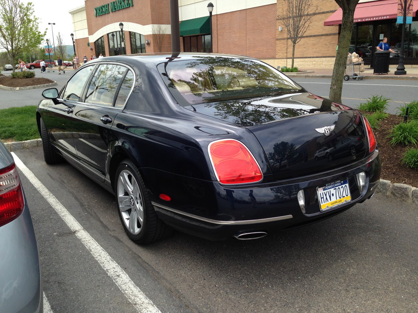 Luxury sedan rear with distinctive large tail lights and dual chrome exhaust tips