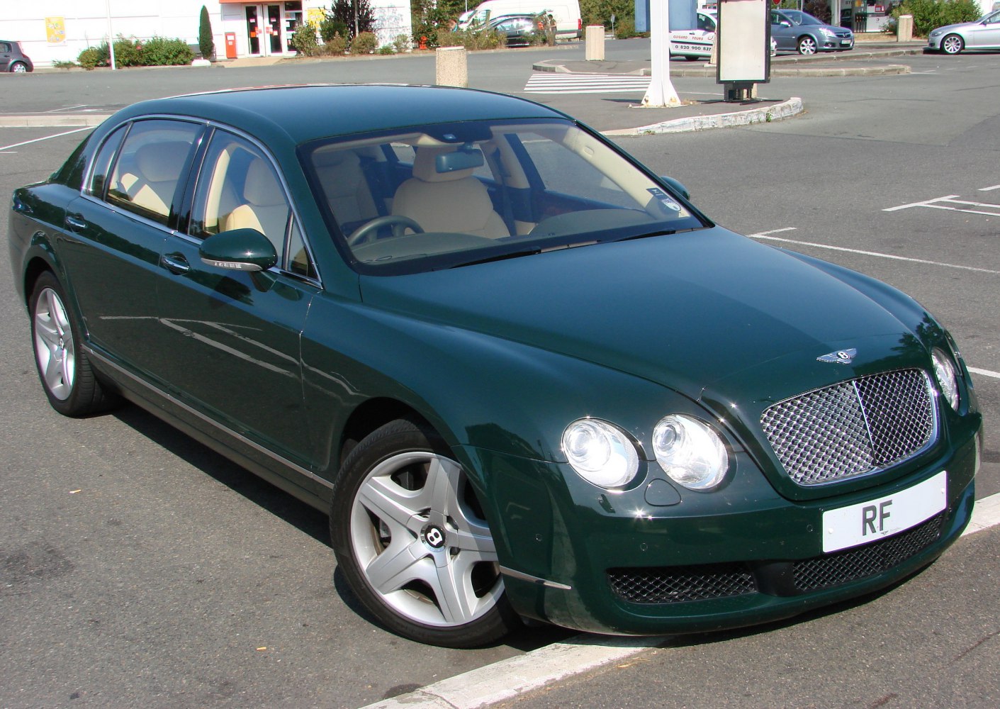 Luxury sedan with large mesh grille and quad round headlights.