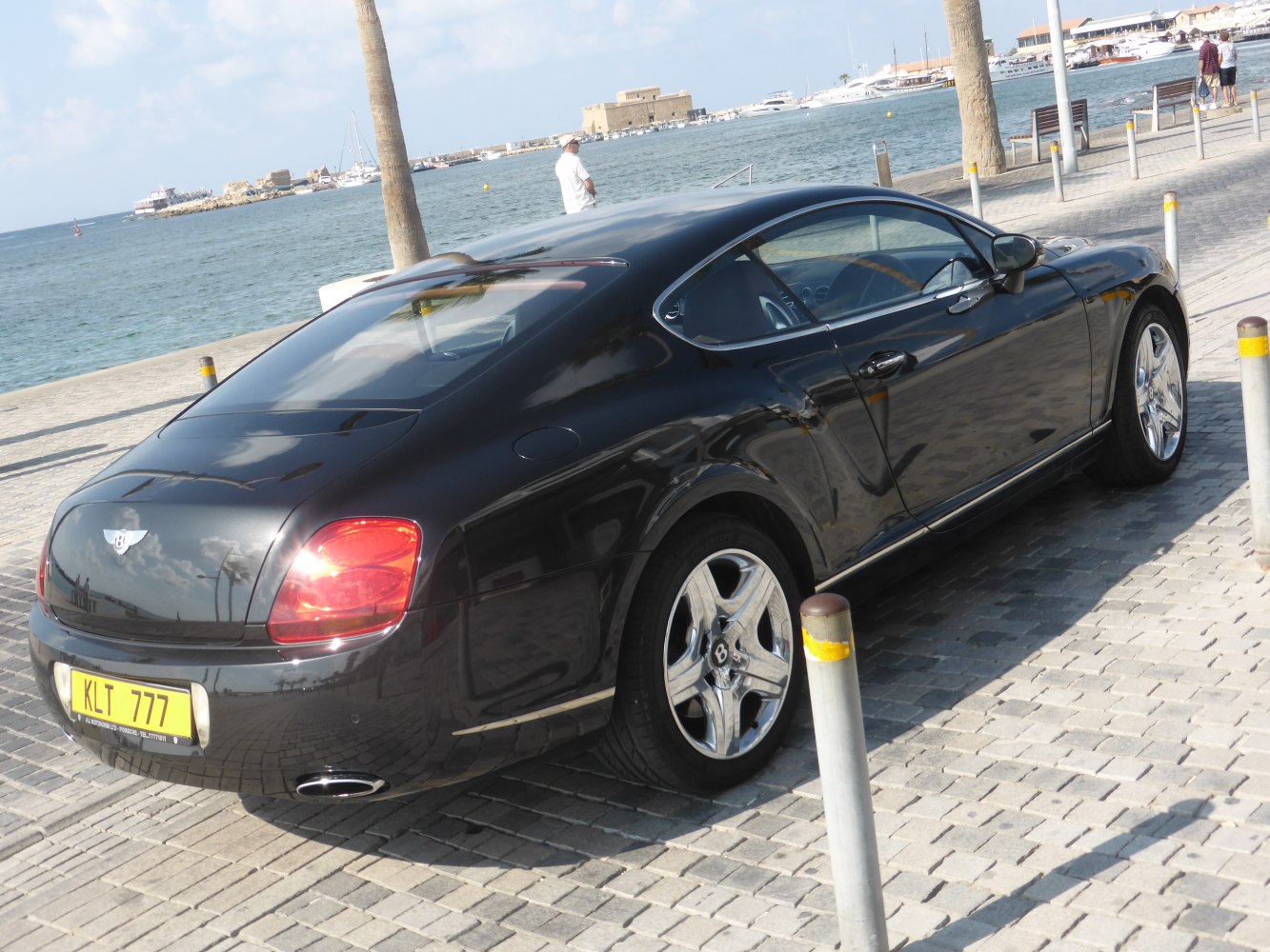 Black luxury coupe with chrome alloy wheels and red rear taillights