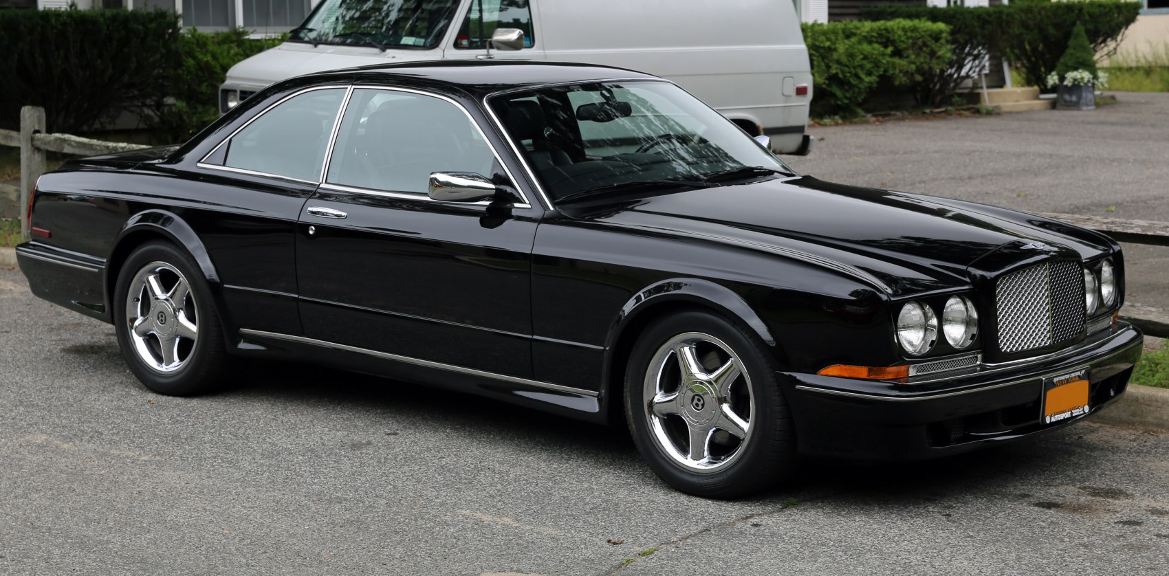 Luxury black coupe with distinctive front grille and chrome wheels