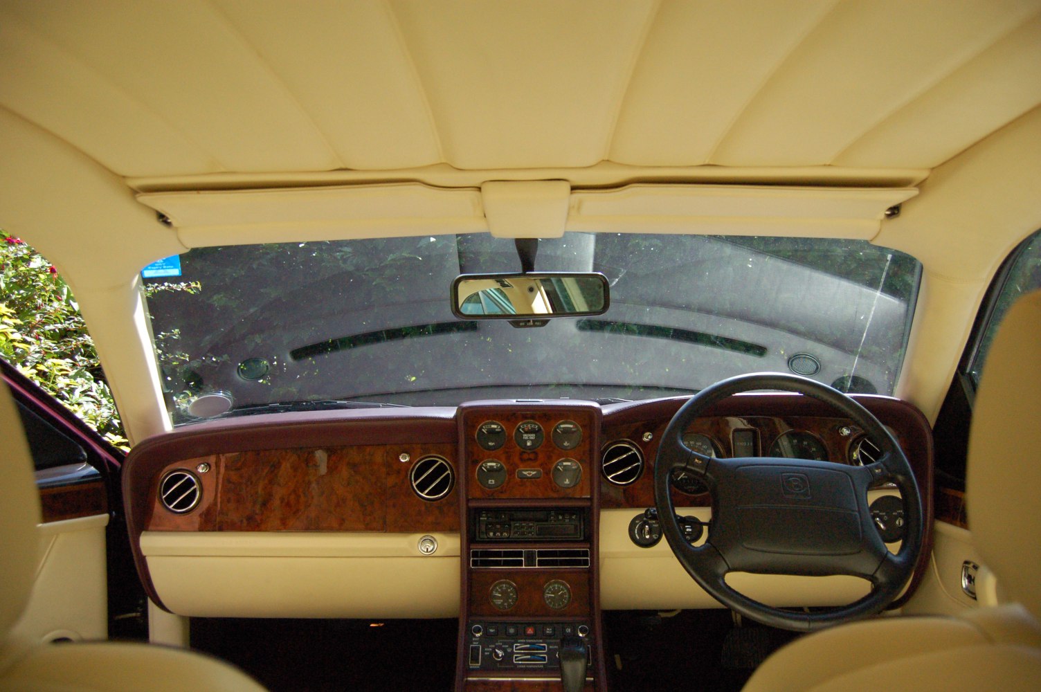 Luxury wood dashboard with analog gauges and vintage controls.