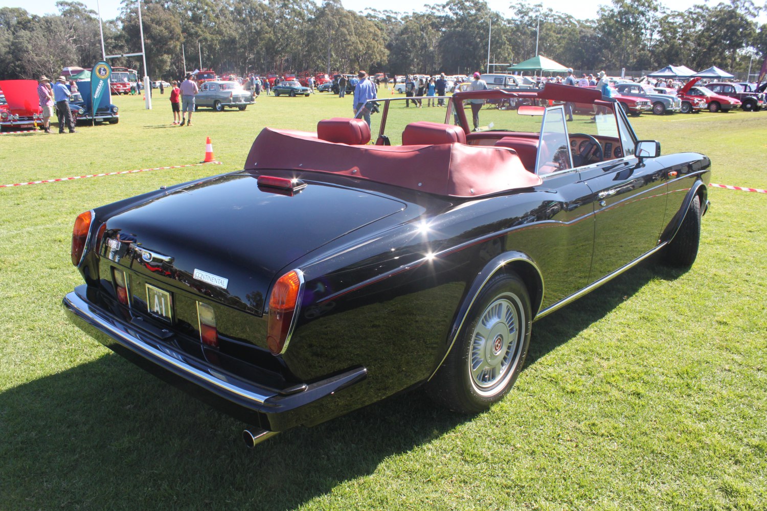 Black convertible with red interior and chrome trim, classic luxury styling
