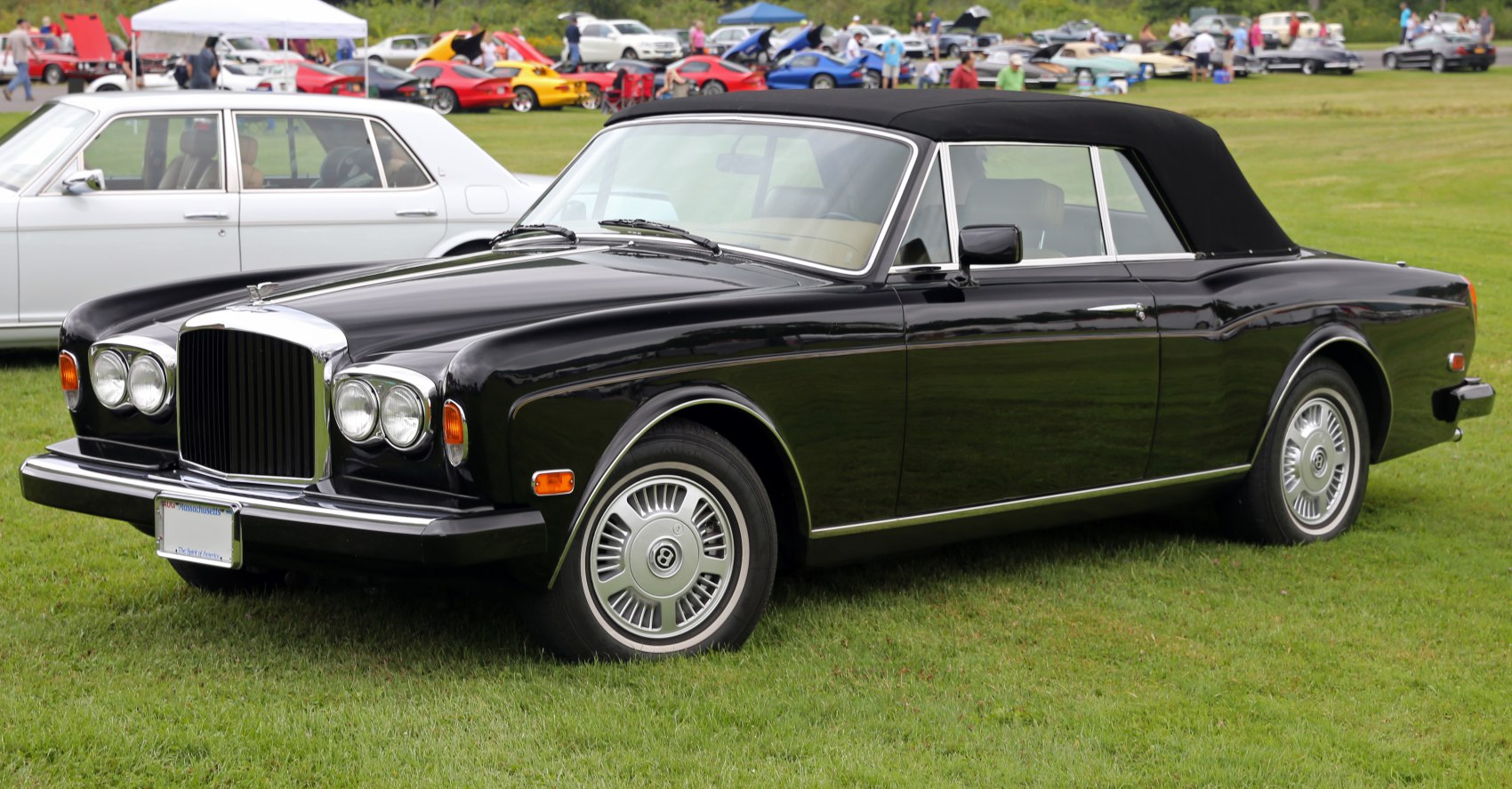 Black convertible luxury sedan with chrome grille and round headlights