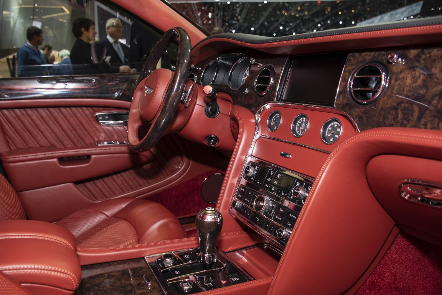 Luxury red leather interior with wood trim dashboard and steering wheel