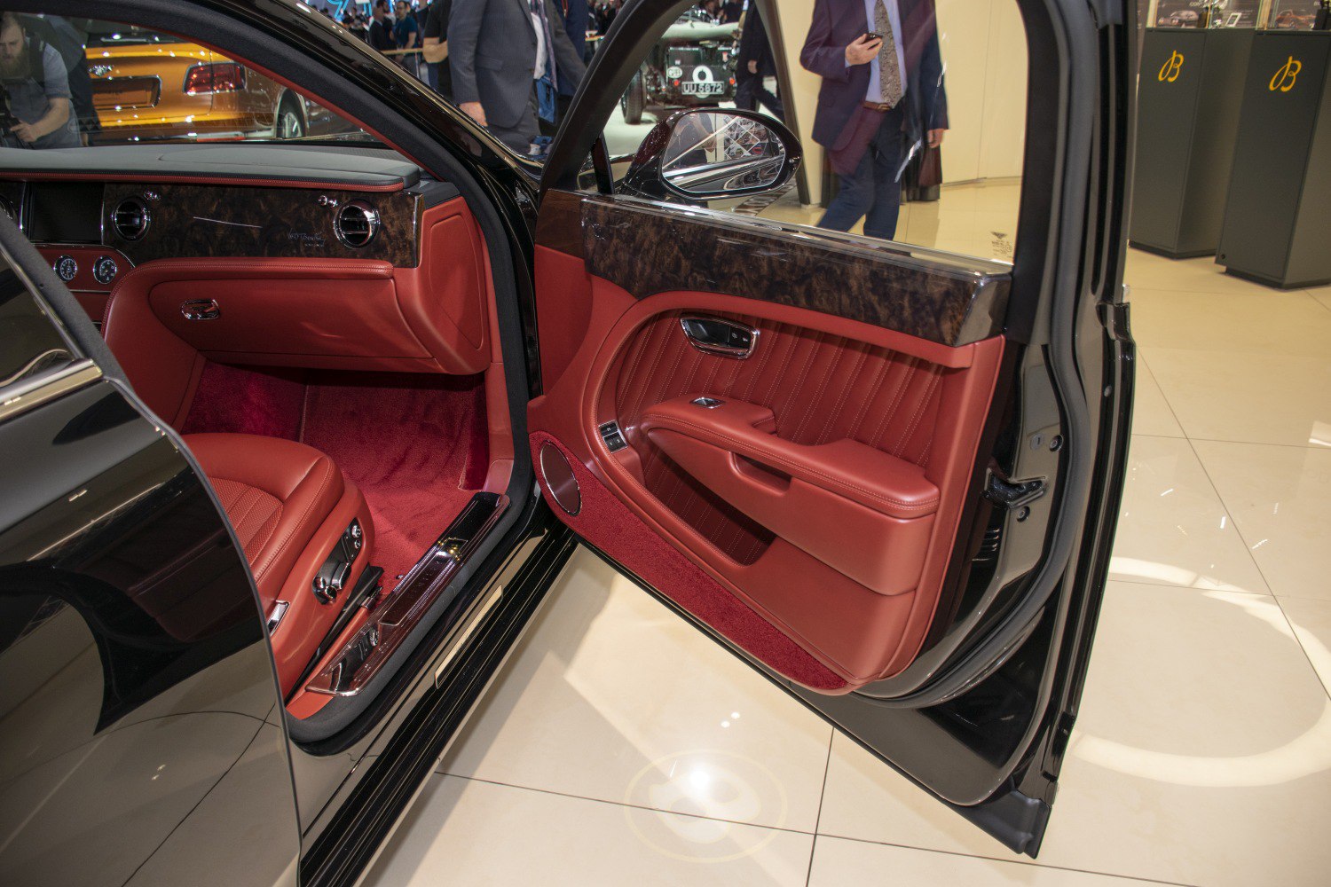 Luxury leather seats and wood trim on car door panel.