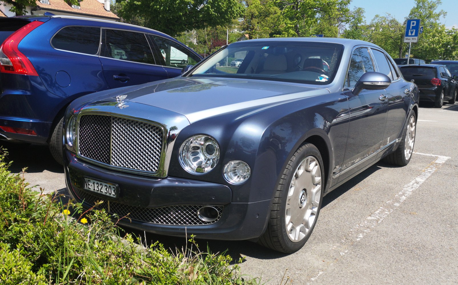 Prominent chrome mesh grille and round quad headlights on a sleek luxury sedan