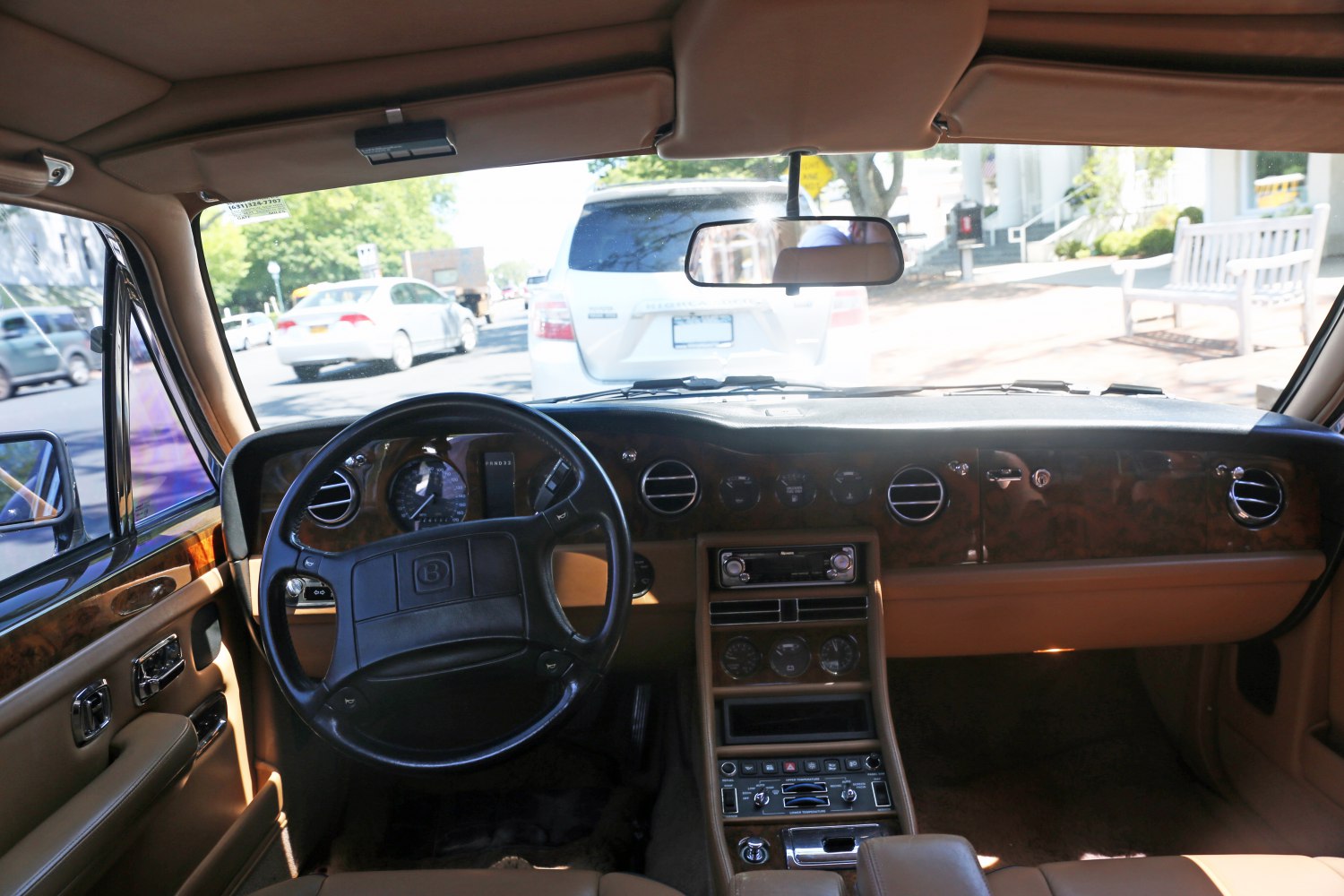 Luxury car interior featuring vintage steering wheel and wood trim dashboard