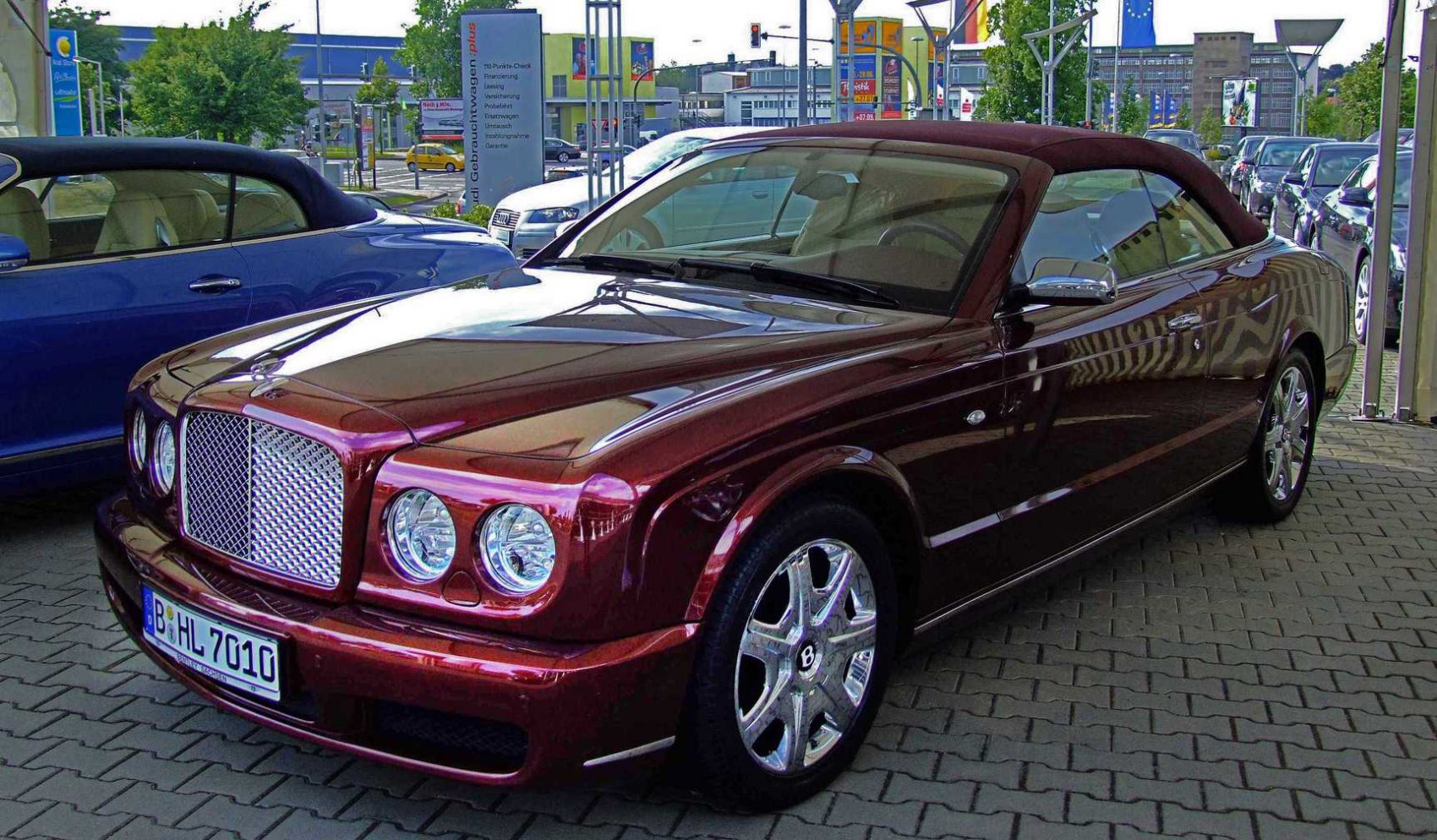 Convertible luxury car with iconic grille and chrome wheels