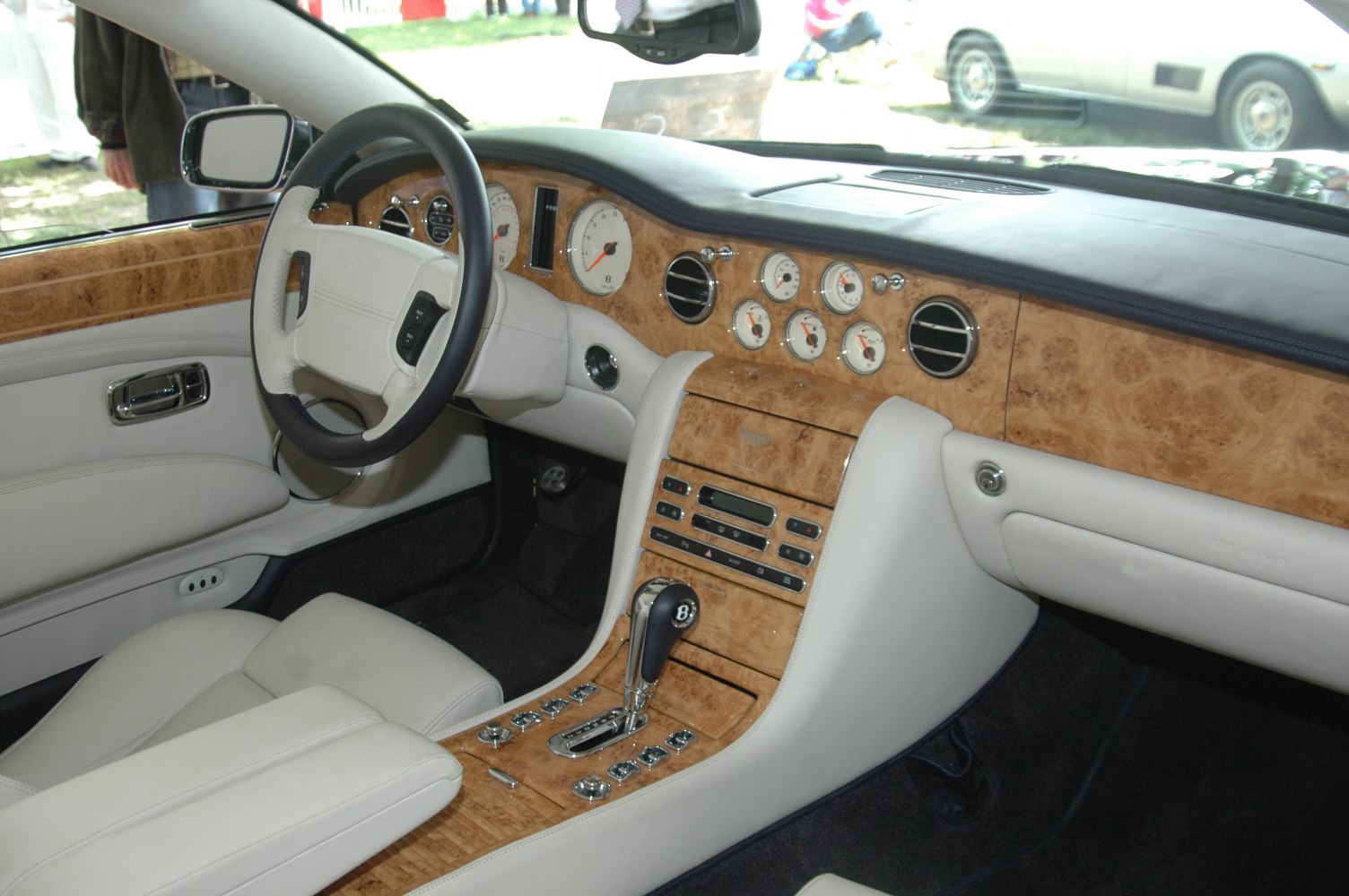 Luxury wood-trimmed dashboard and automatic gear shifter in elegant car interior