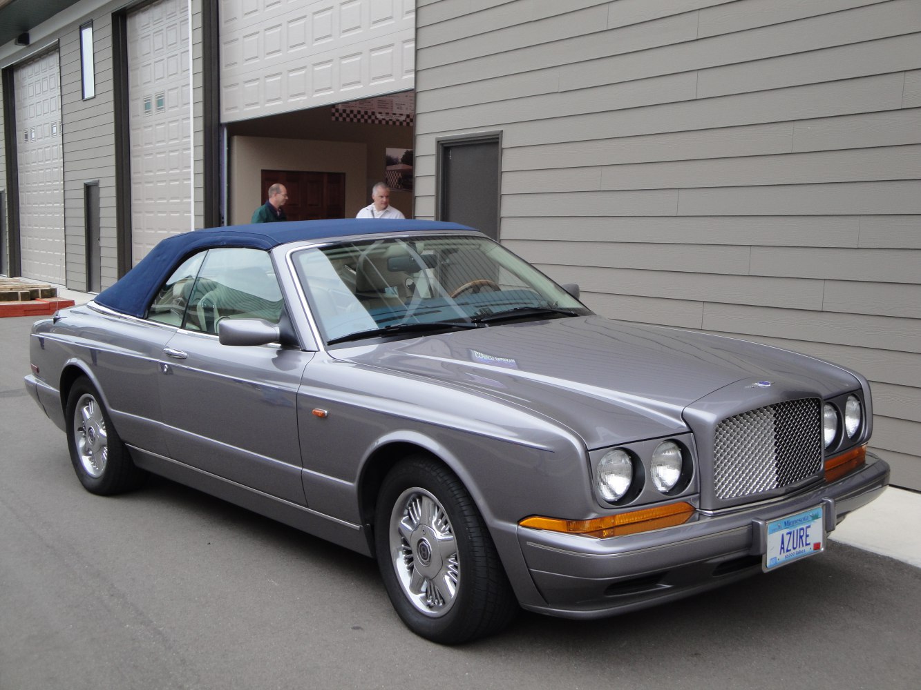 Classic convertible with prominent grille and blue fabric soft top
