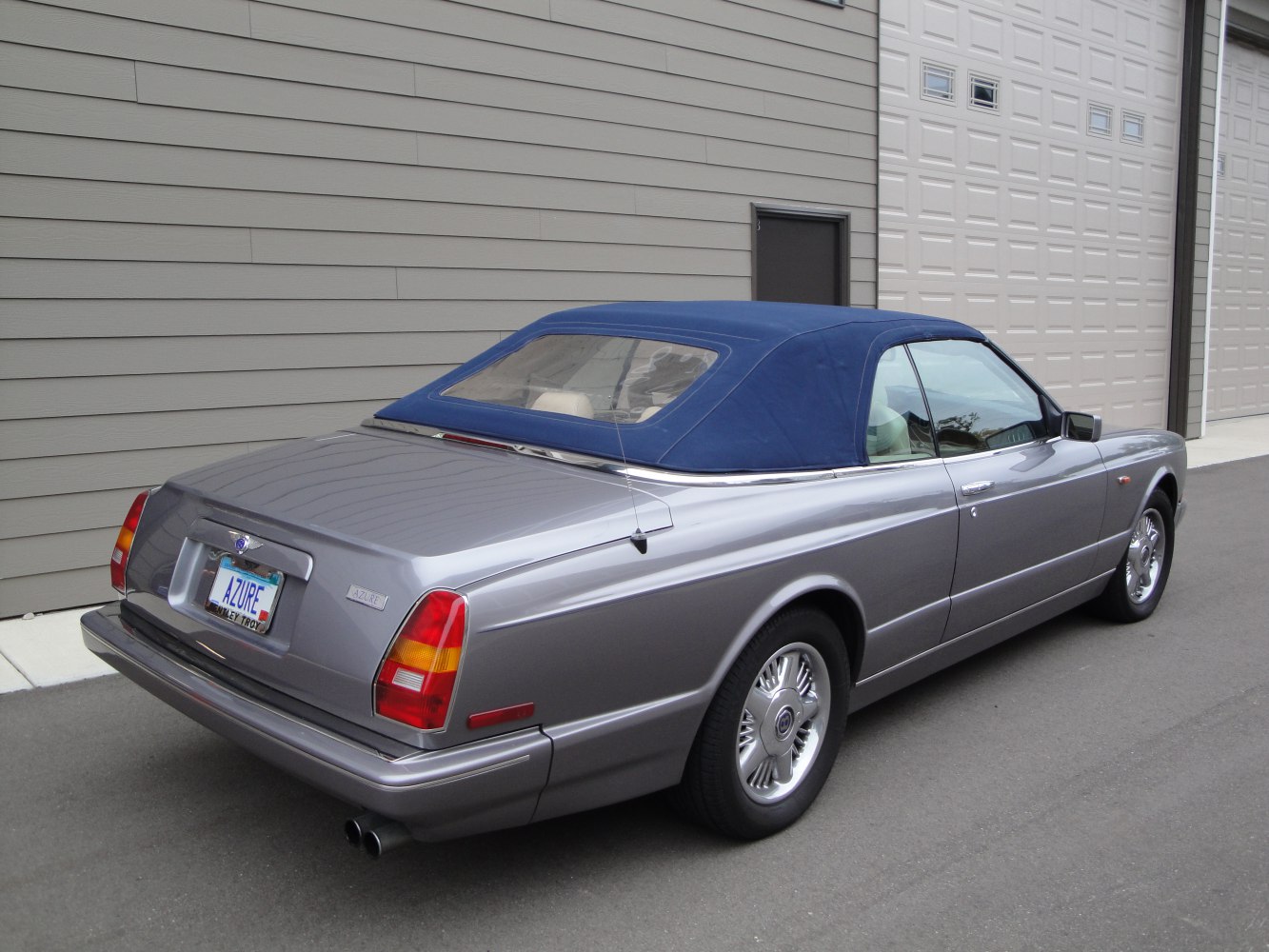 Silver convertible with blue soft top and distinctive rear tail lights