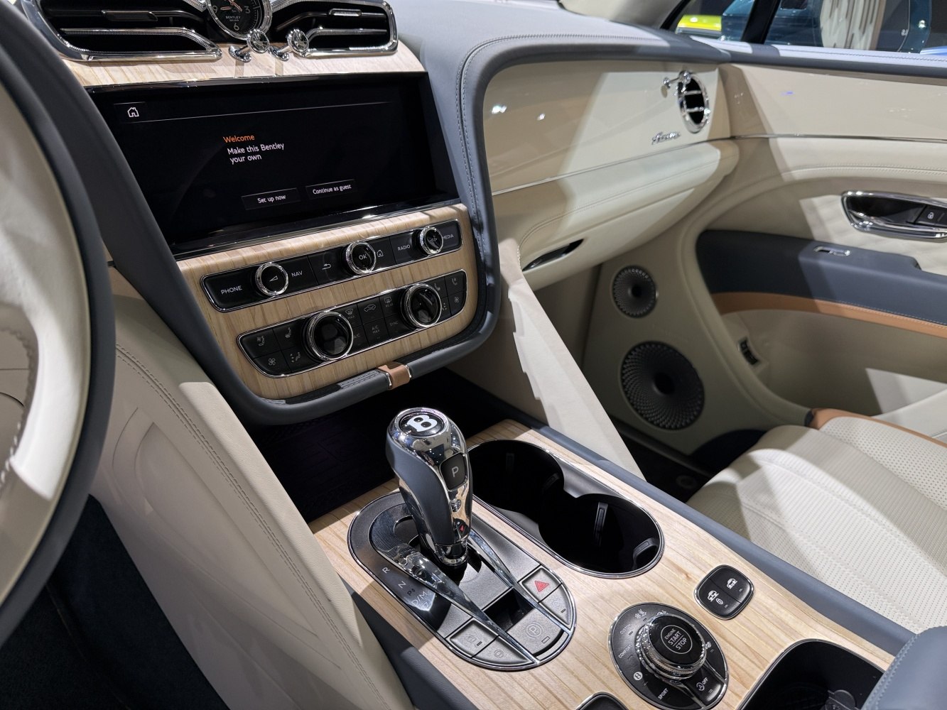 Luxury SUV interior with wood trim, gear selector, and infotainment system