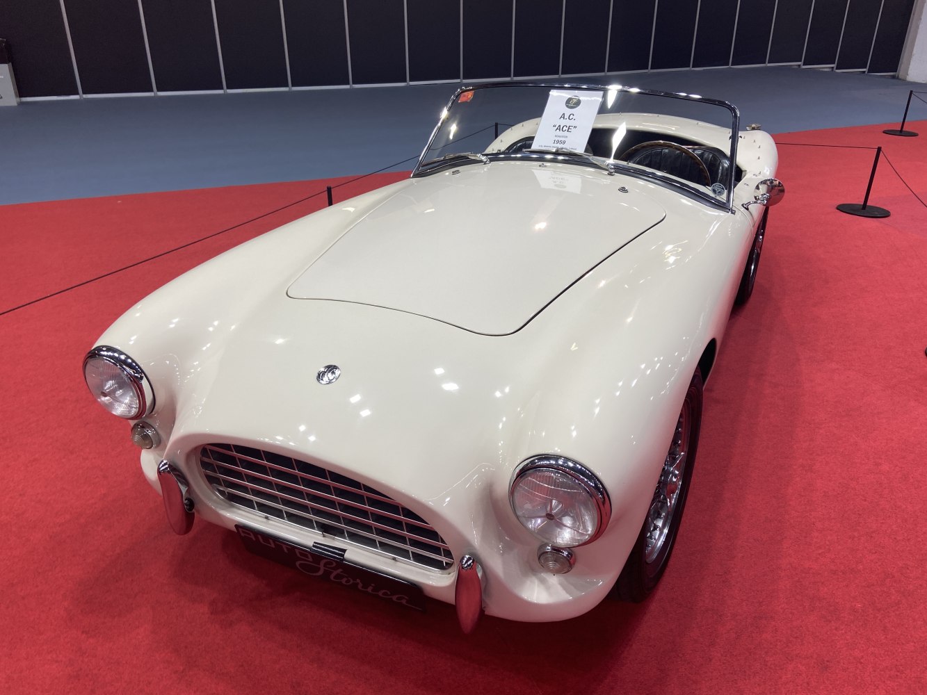 Vintage roadster with rounded headlights, chrome grill, and smooth curved fenders