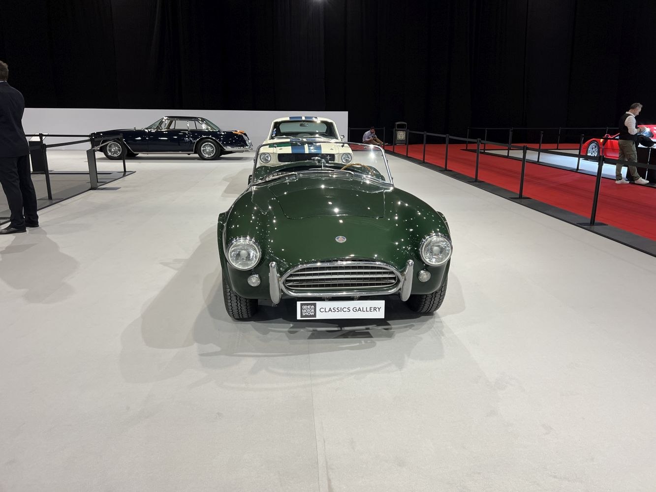 Front view of a classic convertible with round headlights and a wooden steering wheel.